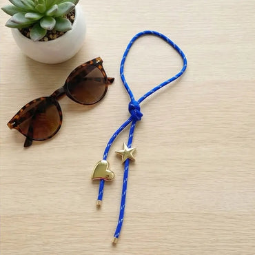Blue paracord necklace with gold heart and star charms styled with sunglasses modern casual jewelry by Julie Saldivia