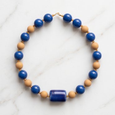 Handmade Cobalt Blue Candy Bead Necklace with glossy blue and neutral beads on white marble background