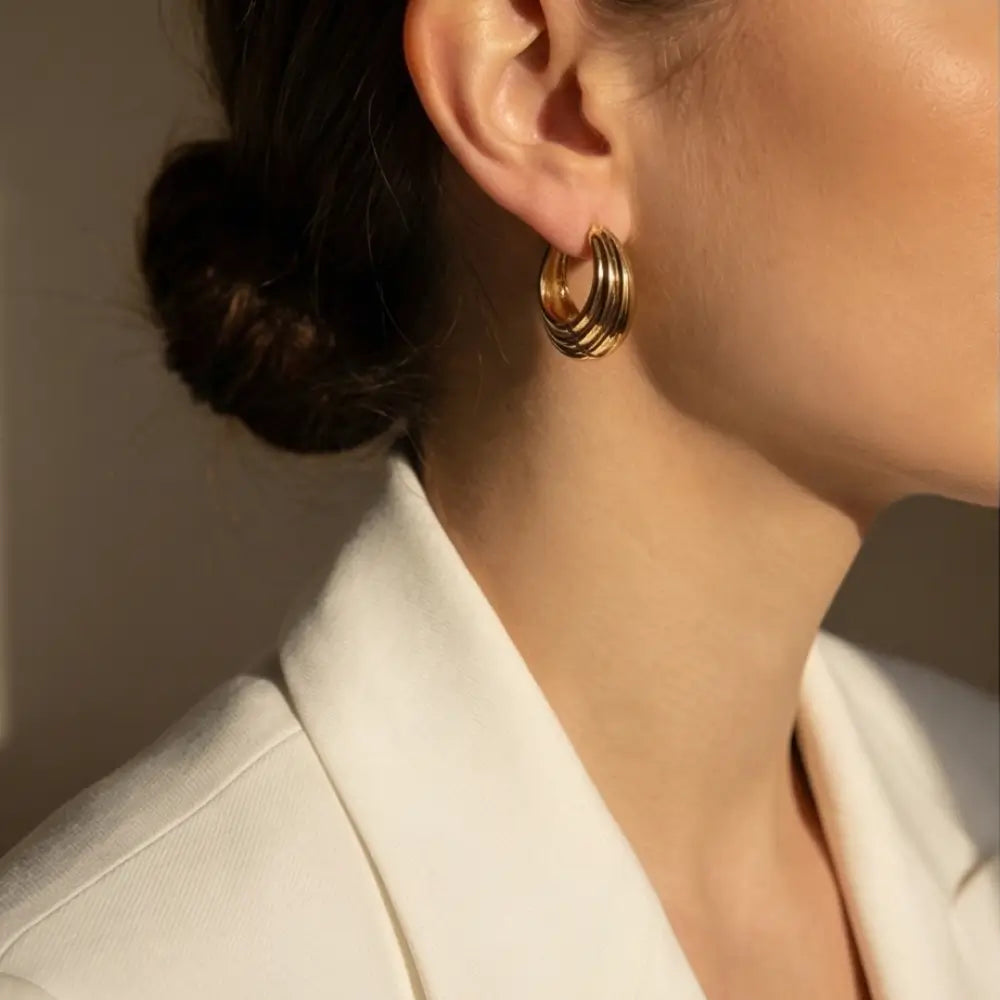 layered gold hoop earrings worn by woman elegant everyday jewelry look