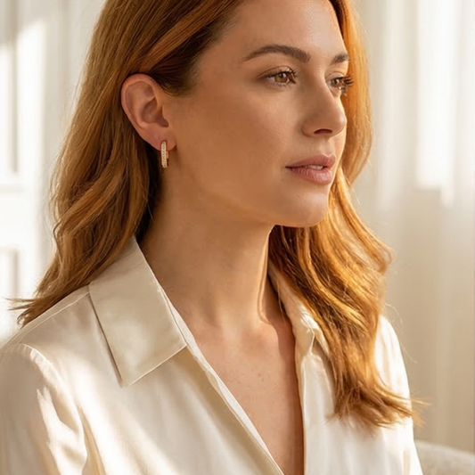Lightweight pavé huggie earrings with crystal detailing displayed on a neutral stone surface