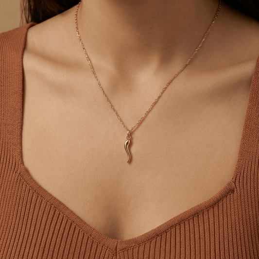Woman wearing minimalist gold Italian horn necklace