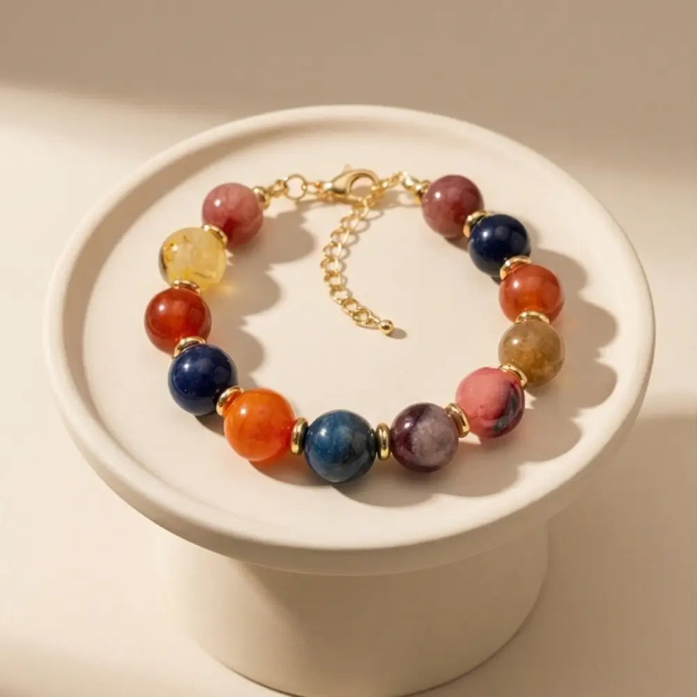 Multicolored beaded bracelet on a white pedestal with a beige background