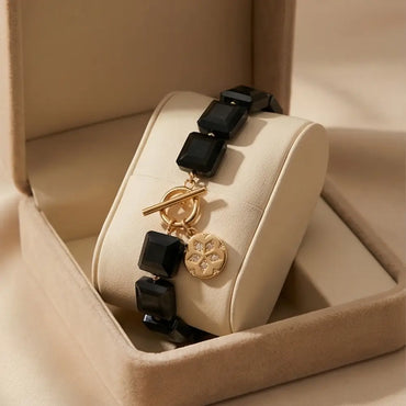 Navy blue gemstone bracelet with gold charm in luxury gift box