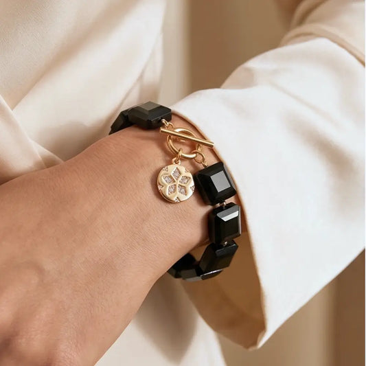 Woman wearing navy blue statement bracelet with gold charm elegant jewelry