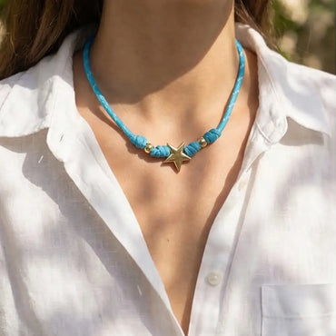 TURQOUISE PARACORD necklace with a star pendant worn by a person in a white shirt.