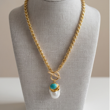 Gold toggle chain necklace with turquoise stone and baroque pearl pendant by Julie Saldivia styled on model and displayed