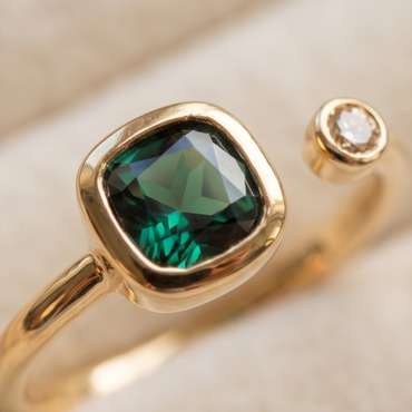 Gold ring with a green gemstone on a beige background