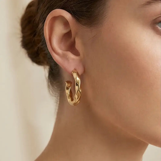 18k gold plated twisted hoop earrings worn by woman bold lightweight statement gold earrings