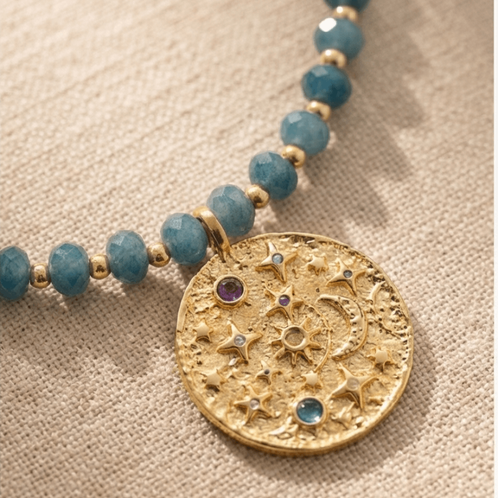 Blue Amethyst Beaded Necklace with Gold Celestial Medallion pendant featuring stars, moon and colorful gemstone details.