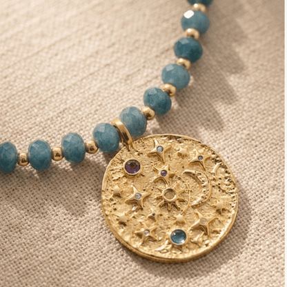 Blue Amethyst Beaded Necklace with Gold Celestial Medallion pendant featuring stars, moon and colorful gemstone details.