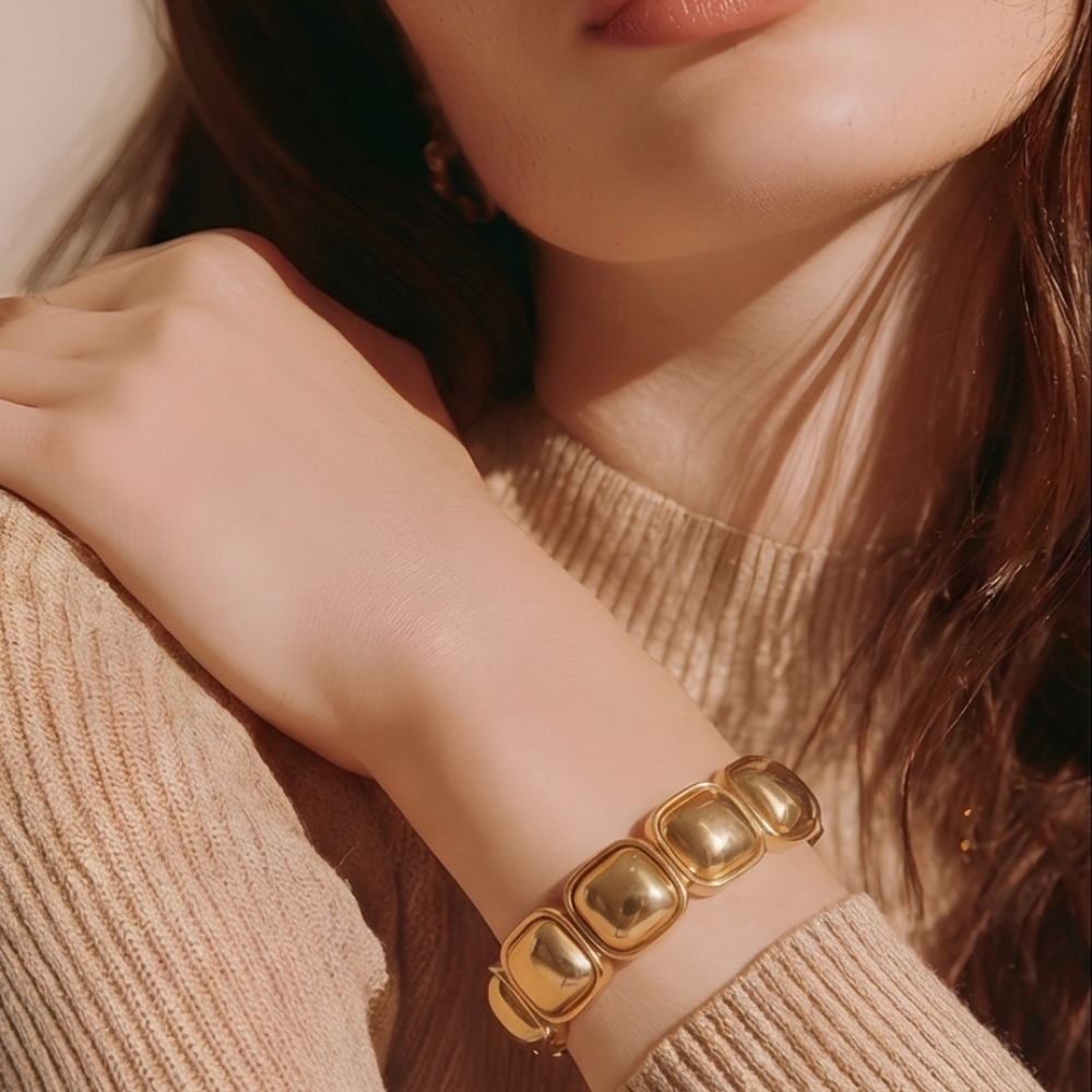 Two tone gold and silver stretch bracelet worn by model holding clutch – modern elastic statement bracelet for women