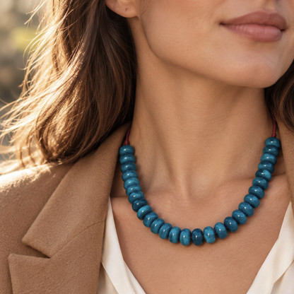 Model wearing the Azure Line blue acrylic bead necklace with an ivory blouse and camel blazer.
