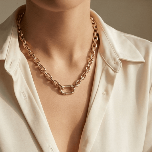 Woman wearing bold gold paperclip chain necklace styled with elegant outfit