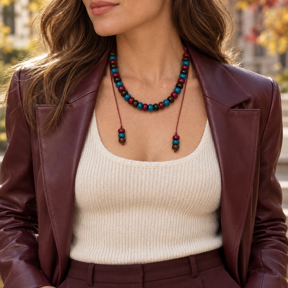 Woman wearing the Bordeaux & Teal Cord Necklace with a cream knit top and burgundy jacket.