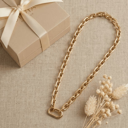 Chunky gold paperclip chain necklace displayed with gift box and neutral styling