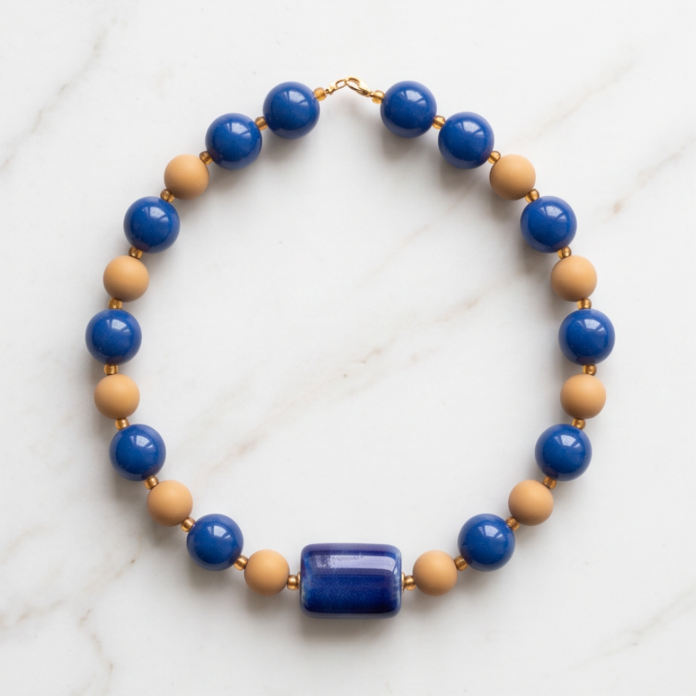 Handmade Cobalt Blue Candy Bead Necklace with glossy blue and neutral beads on white marble background