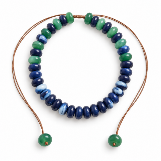 Cobalt-blue, navy and emerald-green donut bead necklace with an adjustable brown cord and green beads at both ends.