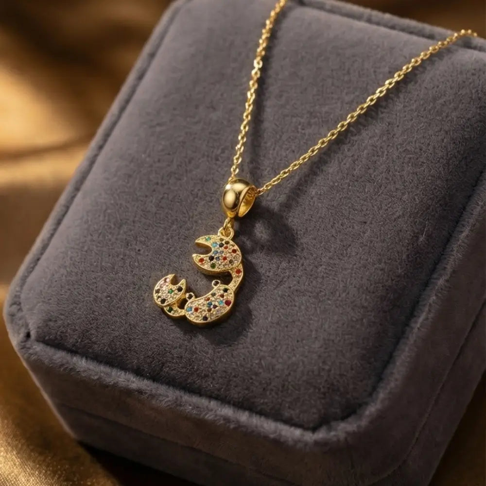 colorful crab pendant necklace gold with multicolor stones displayed on velvet jewelry box