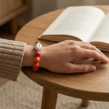 Woman wearing coral gemstone bracelet with pearl elegant jewelry