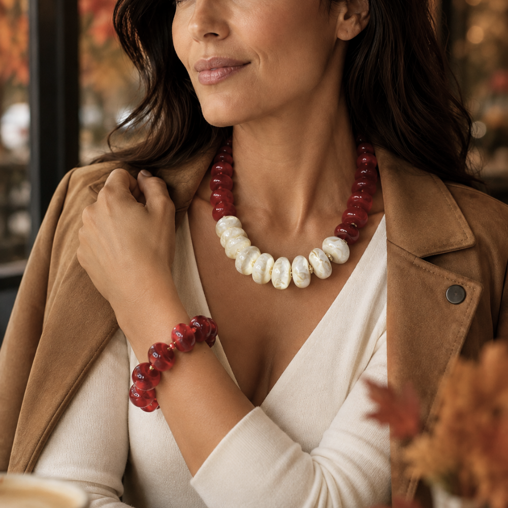 Close-up of woman wearing Crimson Ivory Necklace with crimson red and off-white acrylic beads and matching red bracelet