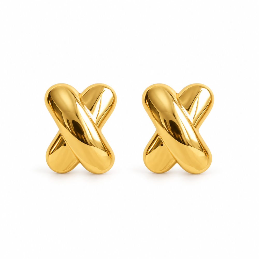 Close-up of a Croisé gold-tone stud earring with smooth rounded curves crossing into an X shape.
