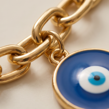 Close-up of blue evil eye charm on Élan Link gold bracelet