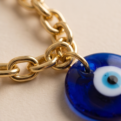 Close-up of Élan Link 18K gold plated chain necklace with blue glass evil eye charm