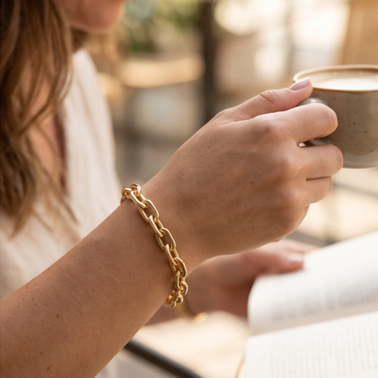 Woman wearing Élan Link gold oval chain bracelet in everyday lifestyle setting