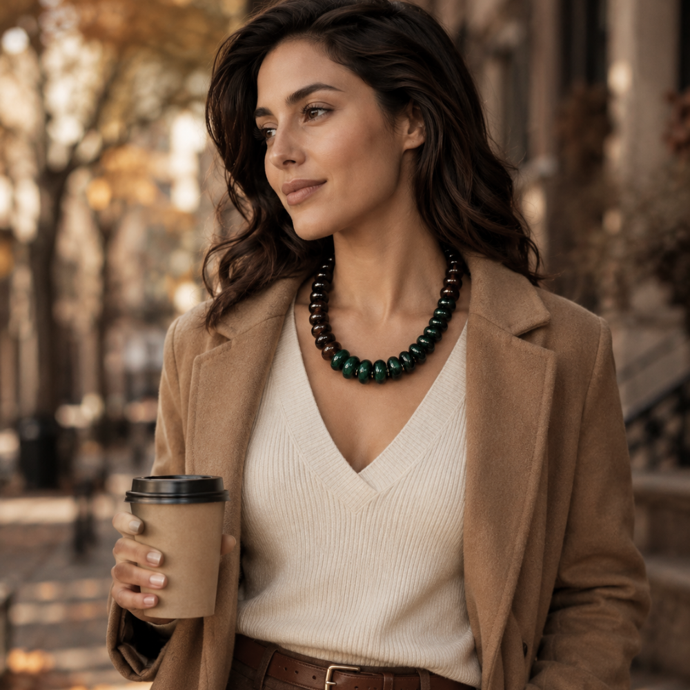 Woman wearing Forest Ember green and brown beaded statement necklace styled with a neutral fall outfit