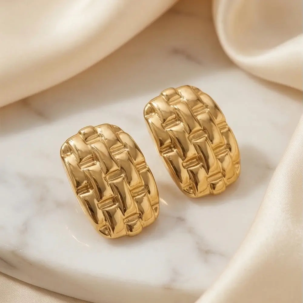 gold chunky textured stud earrings flat lay marble background luxury gold jewelry