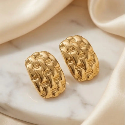 gold chunky textured stud earrings flat lay marble background luxury gold jewelry