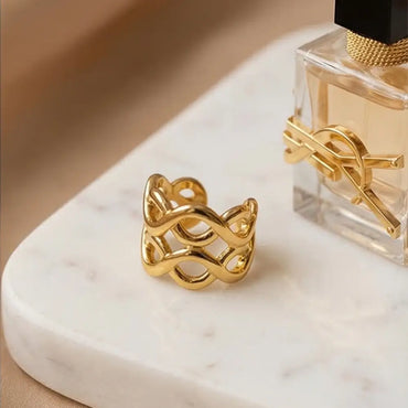 gold crossover ear cuff on marble surface luxury jewelry detail Julie Saldivia