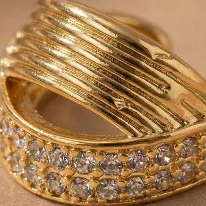Gold ring with diamond accents on a beige background