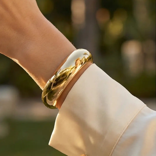 elegant gold bangle bracelet worn by woman minimalist style