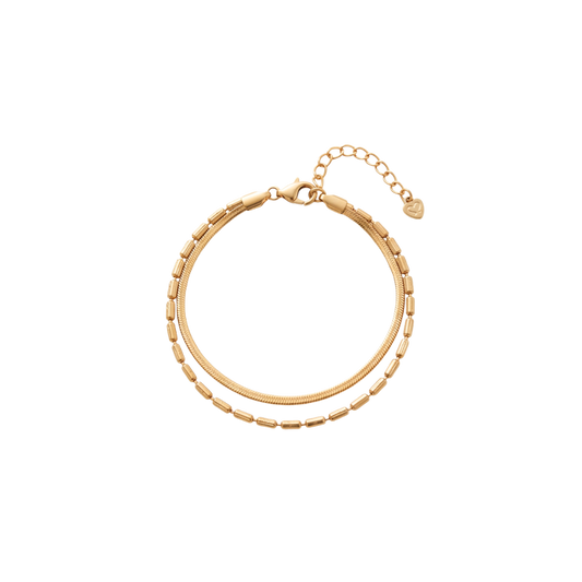 A gold-toned double-strand chain bracelet with a textured outer chain, a smoother inner chain, a lobster clasp, and an extender chain with a small heart-shaped tag, shown on a plain white background.