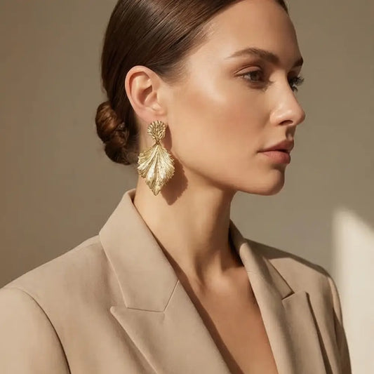 gold leaf statement earrings on woman elegant luxury jewelry handmade julie saldivia beige outfit