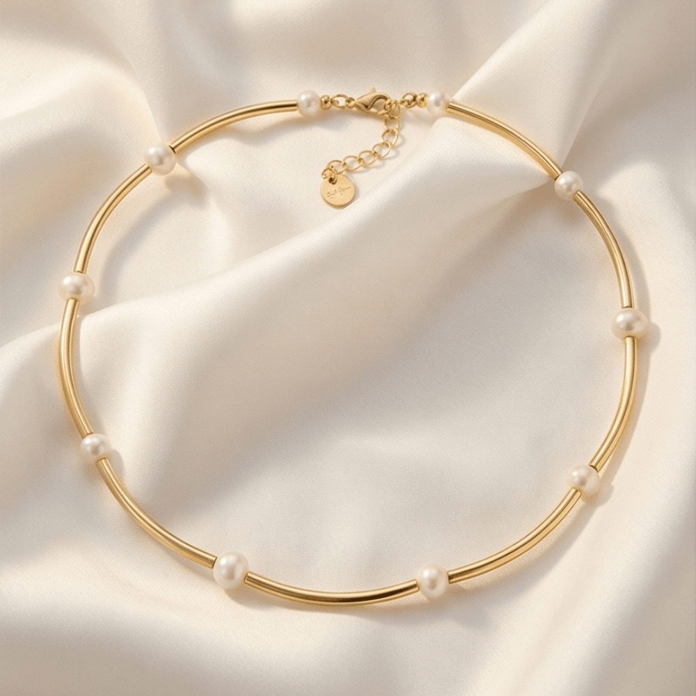 Gold necklace with pearls on a soft beige fabric background