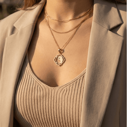 woman wearing gold yin yang lotus necklace minimalist spiritual jewelry outdoor sunlight