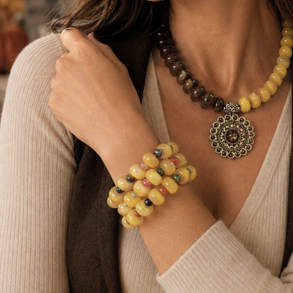 Close-up of woman wearing Golden Earth brown and mustard acrylic bead necklace with antique gold-tone medallion