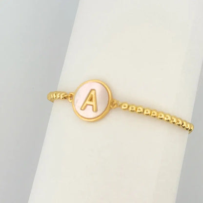 Adjustable gold mother of pearl initial bracelet with sliding clasp and personalized letter charm