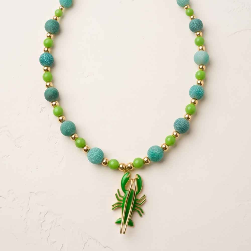 Marina 18-inch green agate necklace with enamel lobster pendant styled with white shirt and hat