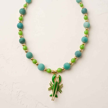 Marina 18-inch green agate necklace with enamel lobster pendant styled with white shirt and hat