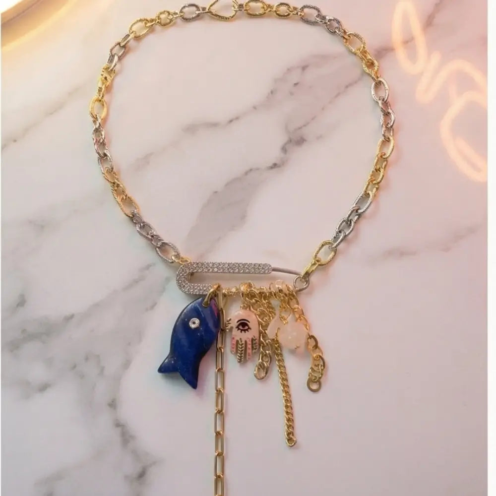 mixed metal charm necklace evil eye hamsa lapis stone gold silver chain flat lay