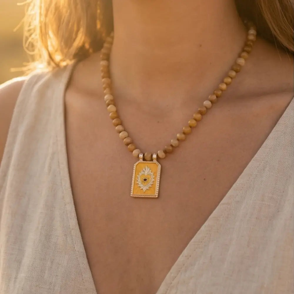 Woman wearing natural stone beaded necklace with sacred heart pendant elegant handmade jewelry