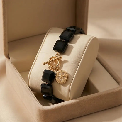 Navy blue gemstone bracelet with gold charm in luxury gift box