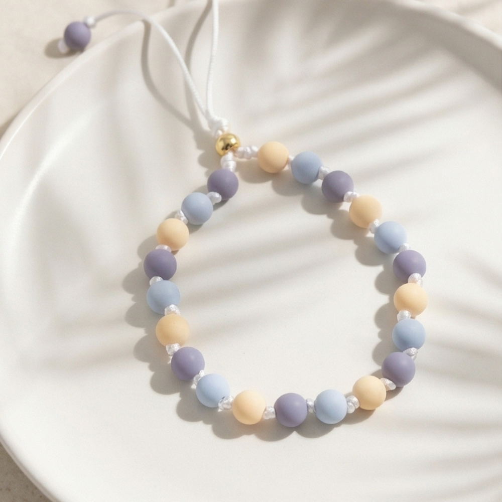 Necklace with pastel-colored beads on a white plate