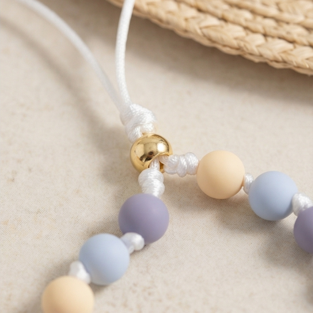 Necklace with pastel-colored beads on a beige surface