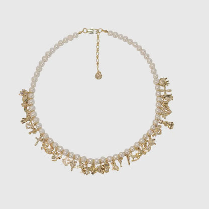 Freshwater pearl necklace with gold charms flat lay, trendy personalized statement necklace Julie Saldivia
