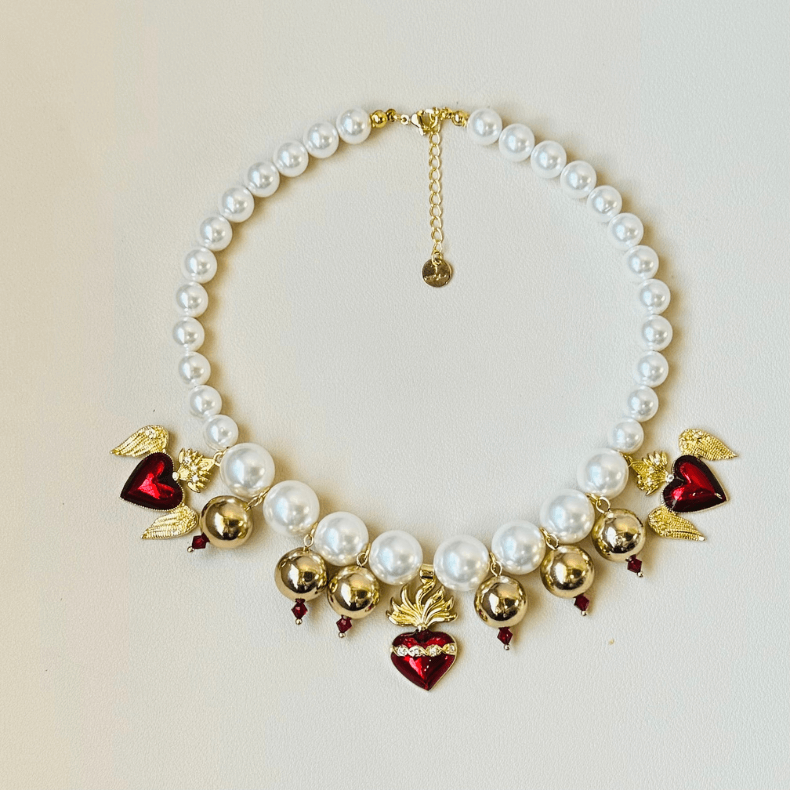 - Pearl heart necklace - Red heart charms - Gold plated necklace - Statement jewelry - Elegant fashion accessory - Handmade necklace - Pearl and gold necklace - Heart charm necklace - Designer necklace - Unique jewelry piece