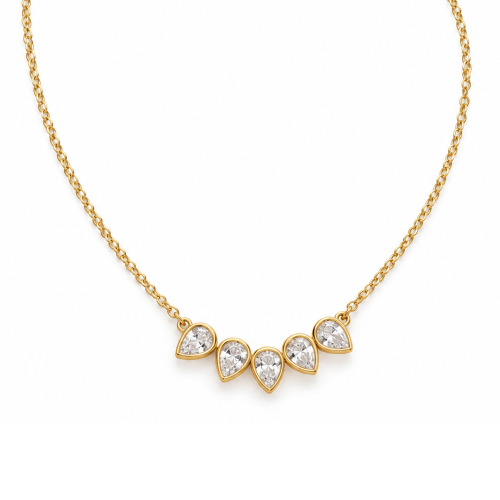 Petal Bezel Necklace by Julie Saldivia featuring five sparkling pear-shaped clear stones in 18K gold-plated 925 sterling silver, with a delicate adjustable chain from 15 to 18 inches, on a white background.
